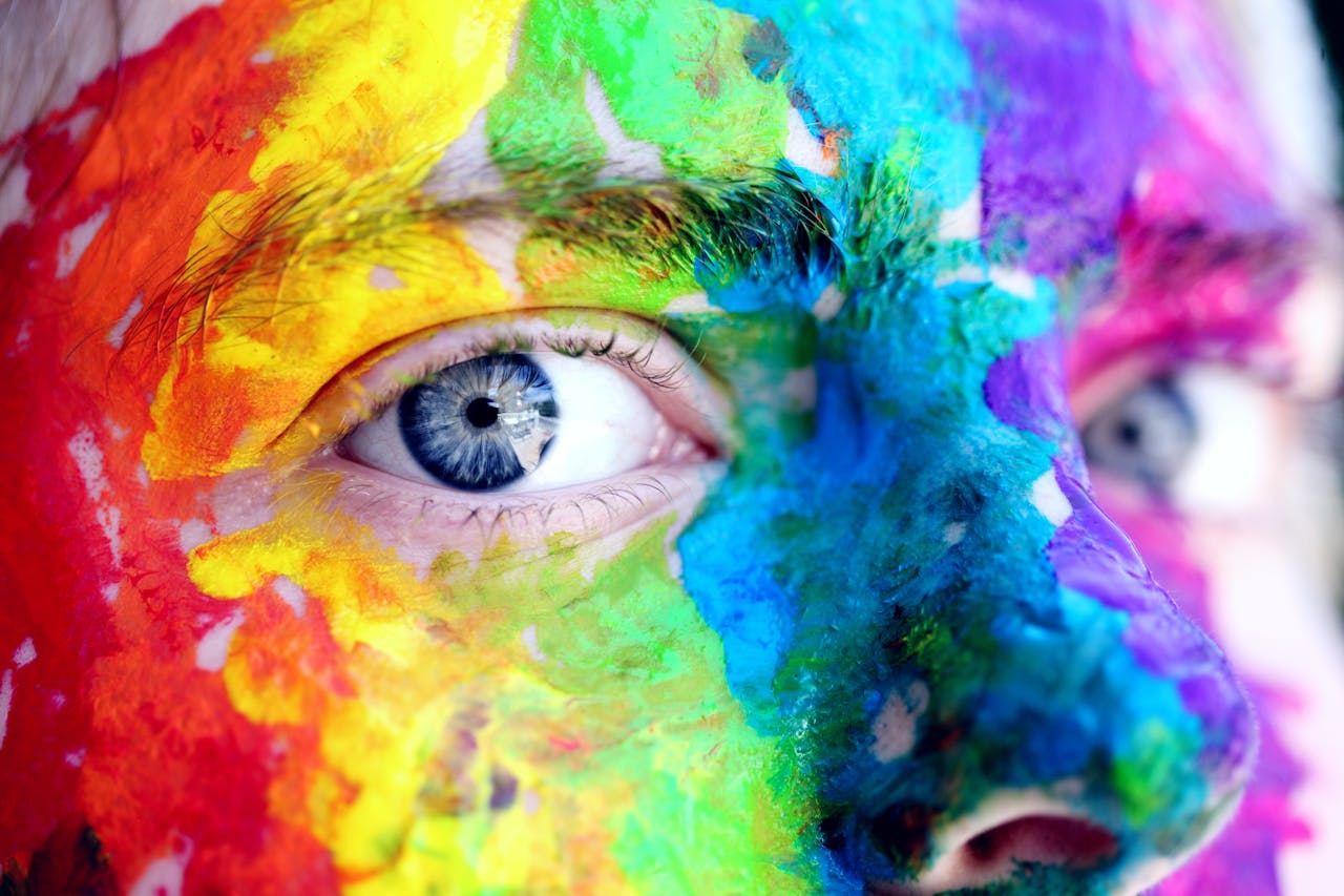 hero-img Close-up of a person with colorful rainbow face paint, symbolizing LGBT pride and expression.