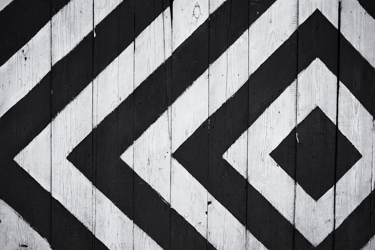 services-04 Black and white geometric pattern on wooden planks, ideal for modern design backgrounds.